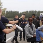 CalaisMigrantCrisisPoliceWithMigrantsJune2015_large